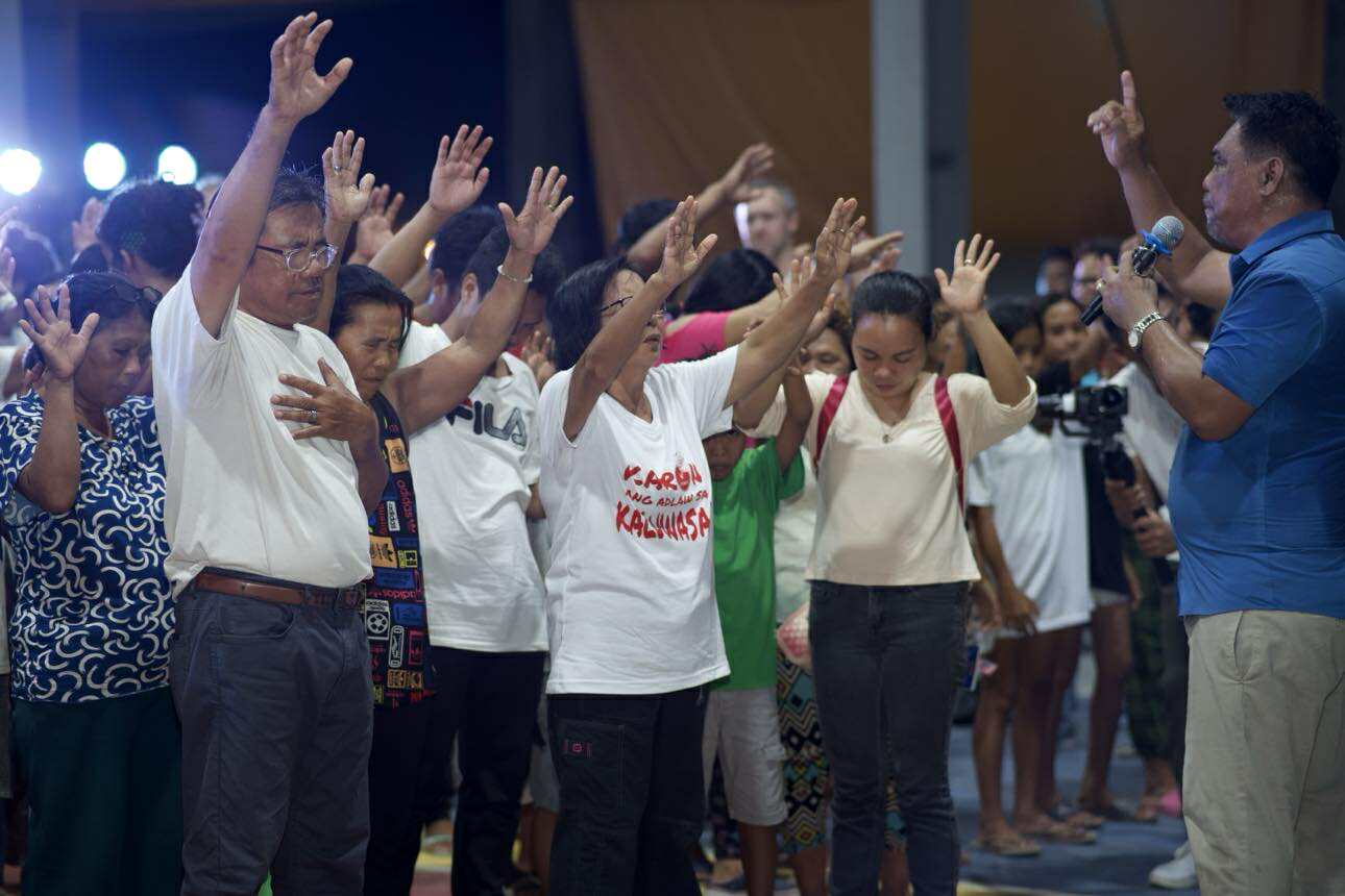 Congregation lifting hands in prayer