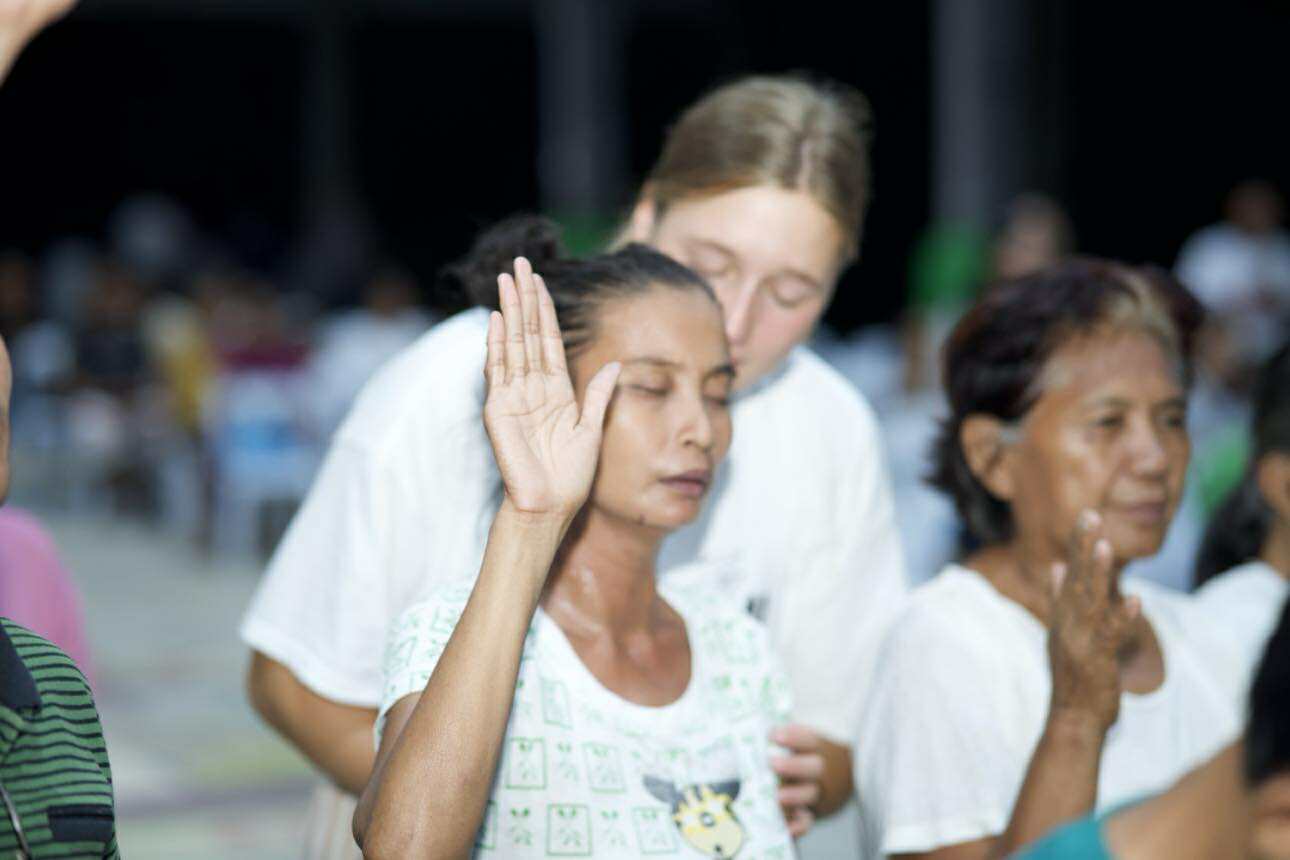 Volunteer praying with a community member