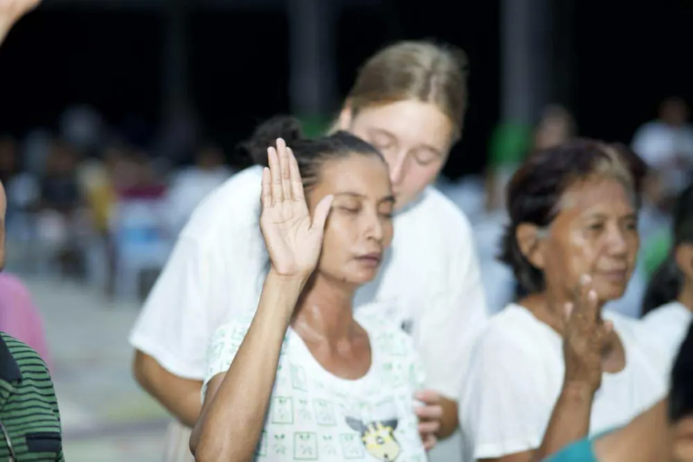 Volunteer praying with a community member
