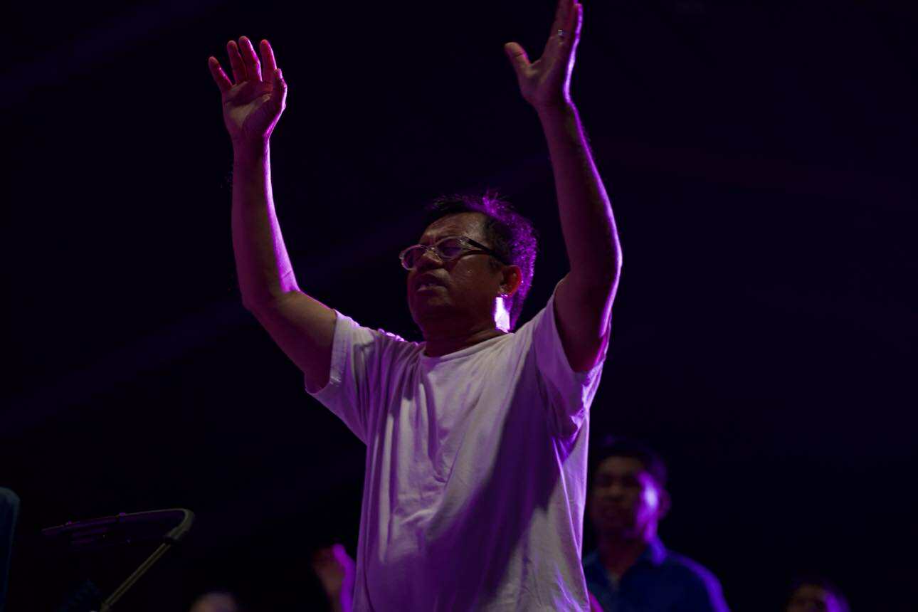 Worshipper lifting hands in purple light
