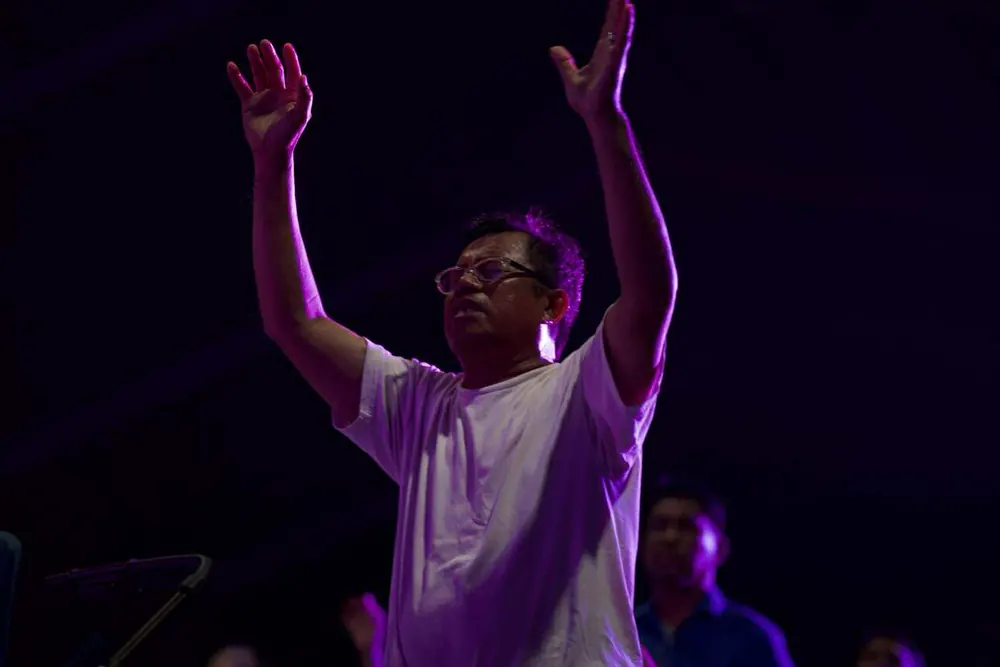 Worshipper lifting hands in purple light
